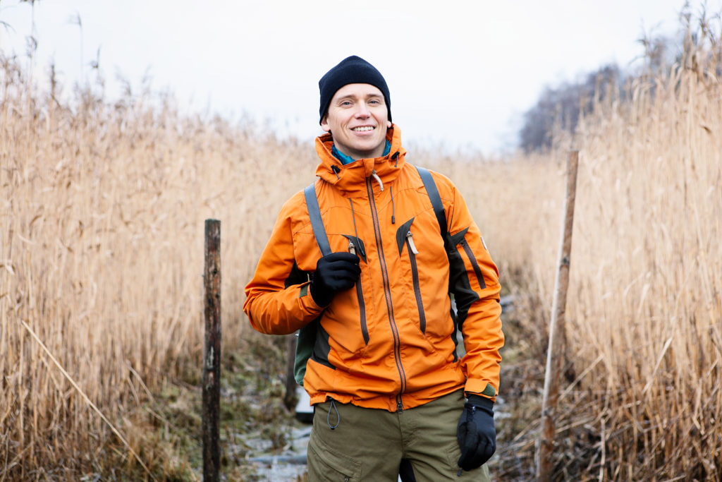 Mies oranssissa takissa seisoo keskellä kuivaa